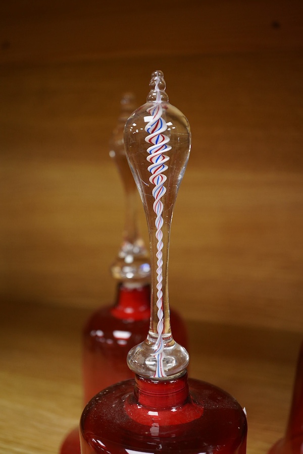 Seven Victorian cranberry glass bells, one with patriotic opaque twist handle, largest 30cm high. Condition - fair/good